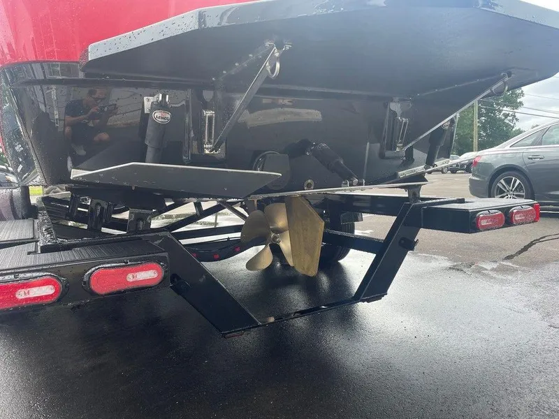 Slide: The Image of 2024 Moomba Tykon boat propeller and trailer detail, parked on wet pavement. - 22