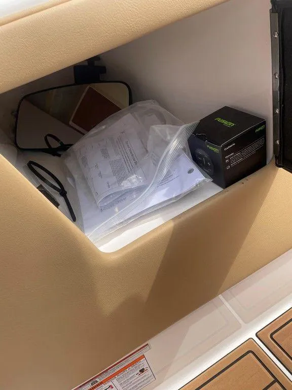 Slide: The Image of 2024 Moomba Tykon storage compartment with documents and a small box. - 25