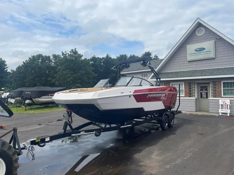 Slide: The Image of 2024 Moomba Tykon boat on trailer outside dealership, cloudy sky background. - 28