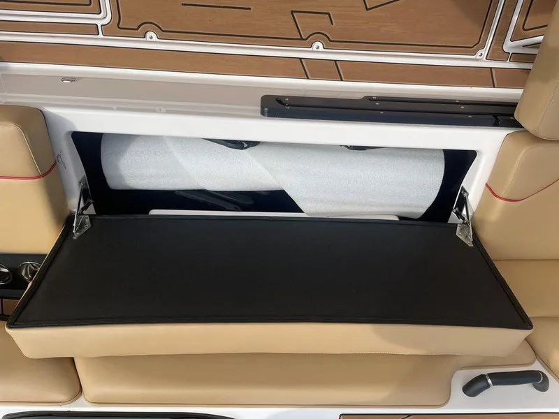 Slide: The Image of 2024 Moomba Tykon boat storage compartment with beige seating and black lid. - 3