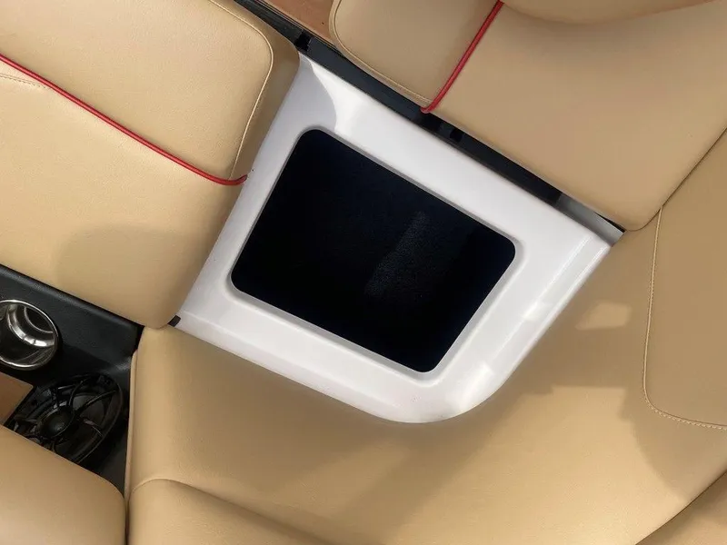 Slide: The Image of 2024 Moomba Tykon interior with beige leather seats and storage compartment. - 33