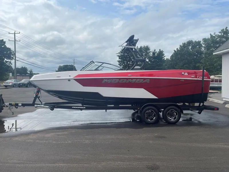 Slide: The Image of 2024 Moomba Tykon boat on trailer, red and white design, parked outdoors. - 36