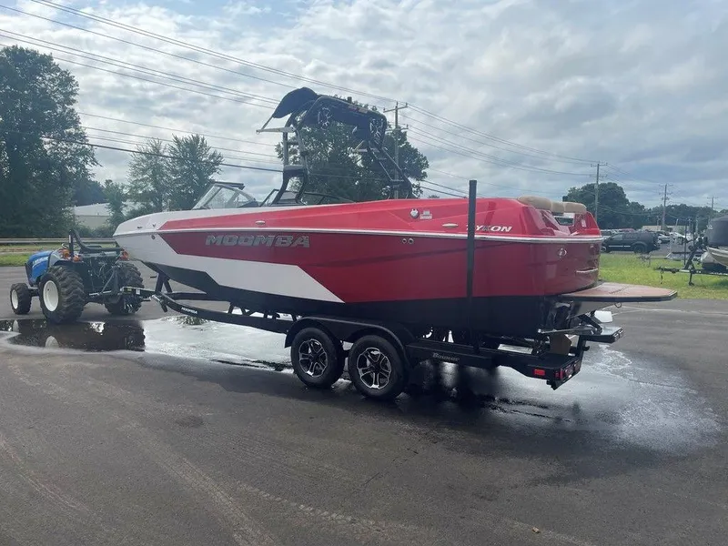 Slide: The Image of 2024 Moomba Tykon boat on trailer, red and white design, parked outdoors. - 38