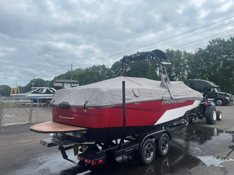 Slide: The Image of 2024 Moomba Tykon boat with cover on trailer, parked outdoors. - 44