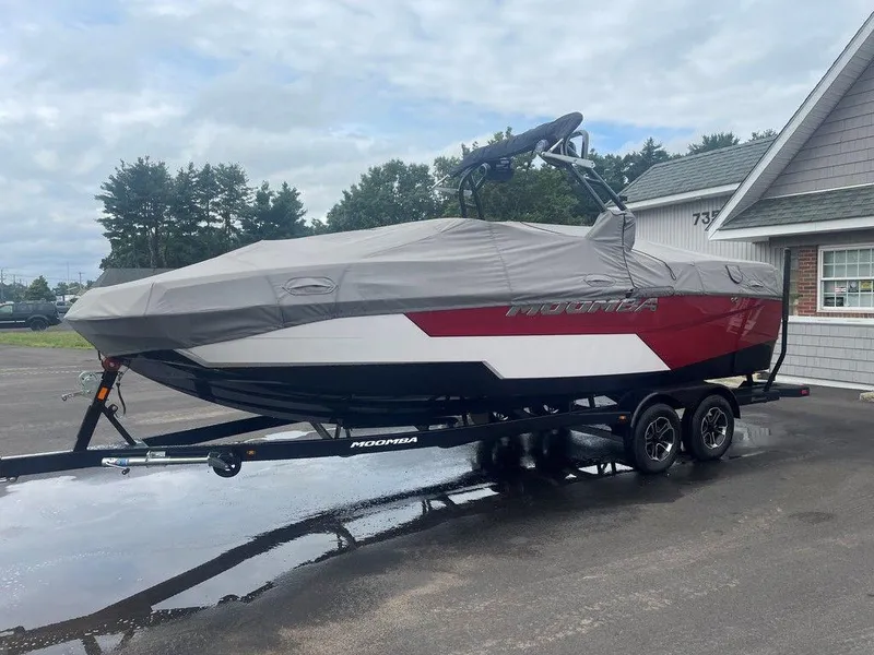 Slide: The Image of 2024 Moomba Tykon boat covered on trailer, parked near a building. - 9