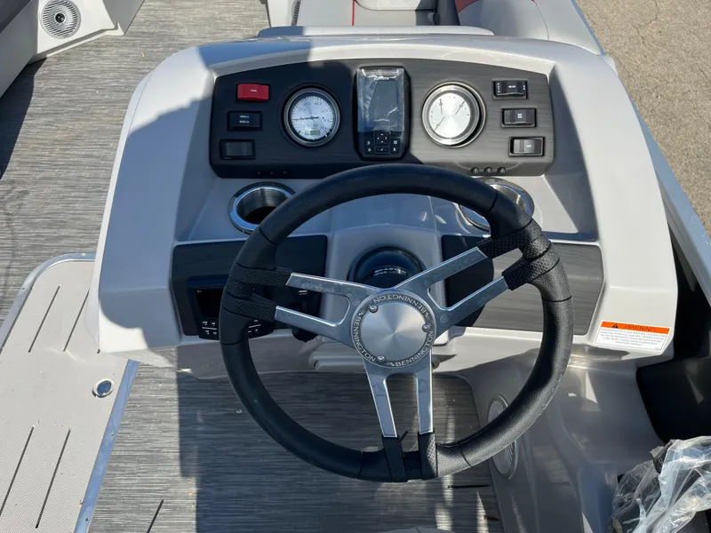 Slide: The Image of 2023 Bennington SX Line boat dashboard with steering wheel and control gauges. - 4