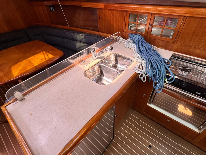 Slide: The Image of 2005 Hunter 38 yacht interior with kitchen sink, stove, and dining area. - 19