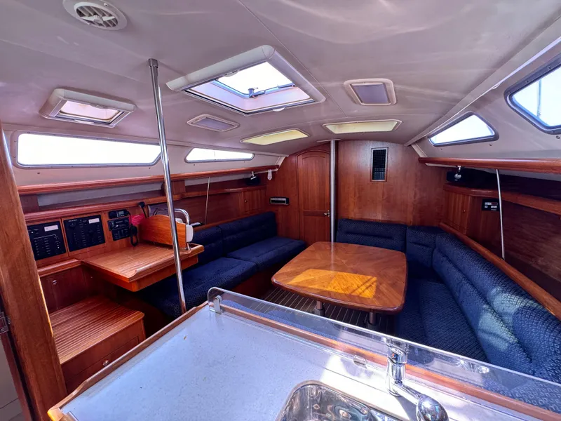 Slide: The Image of Interior of 2005 Hunter 38 sailboat with wood finish and seating area. - 20