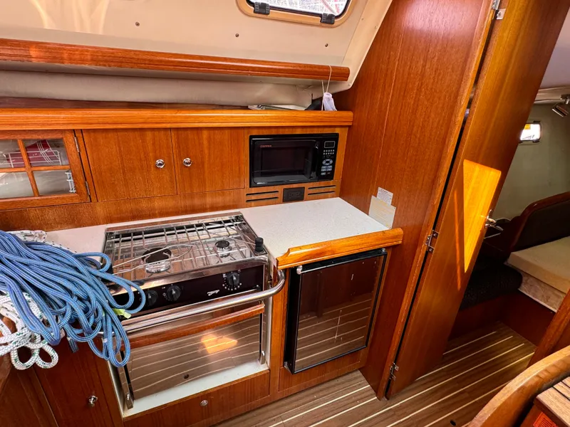 Slide: The Image of 2005 Hunter 38 yacht kitchen with stove, microwave, and compact fridge. - 21