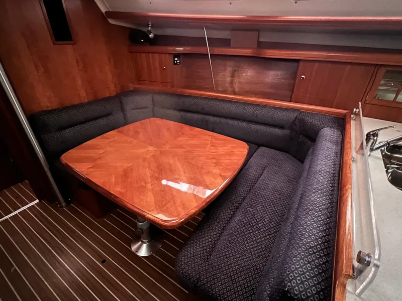 Slide: The Image of 2005 Hunter 38 sailboat interior with wooden dining table and cushioned seating. - 25