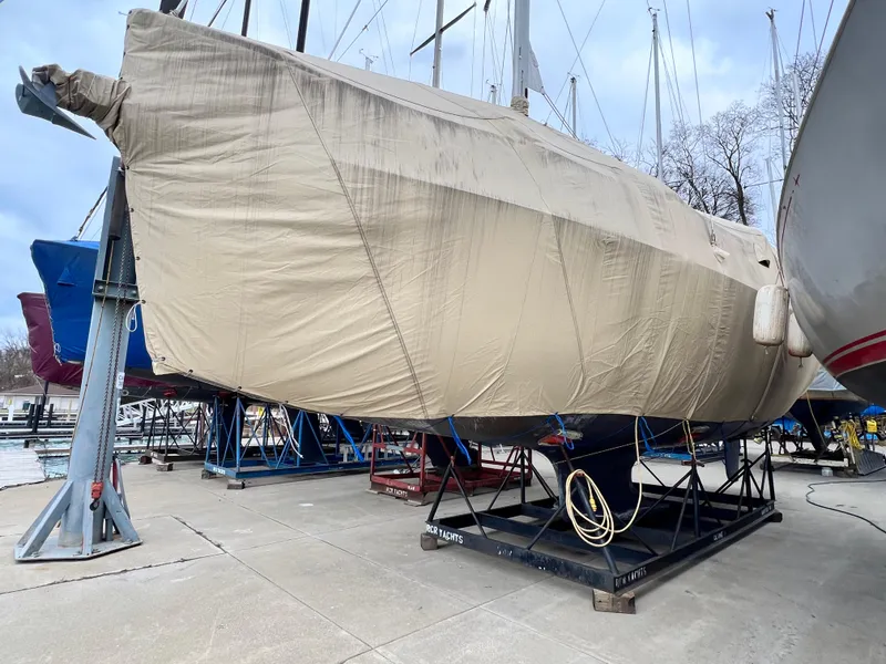 Slide: The Image of 2005 Hunter 38 sailboat covered and stored on a boatyard stand. - 34