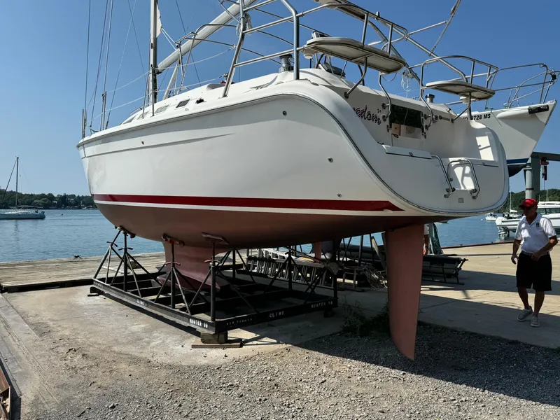 Slide: The Image of 2005 Hunter 38 sailboat on dry dock, marina background, clear sky. - 5