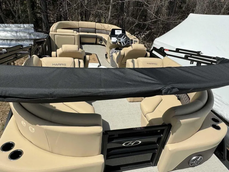 Slide: The Image of 2024 Harris Sunliner 230 pontoon boat with beige seating and black accents. - 4