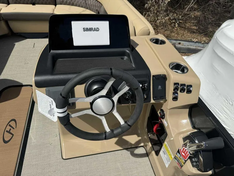 Slide: The Image of 2024 Harris Sunliner 230 boat helm with Simrad display and steering wheel. - 5