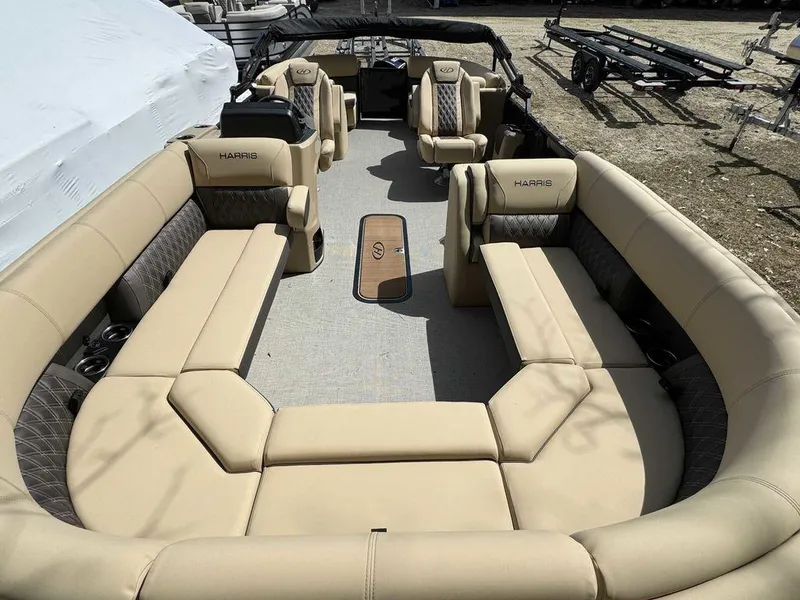 Slide: The Image of 2024 Harris Sunliner 230 pontoon boat with spacious beige seating. - 6