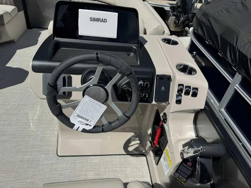 Slide: The Image of 2024 Harris Sunliner 210 boat dashboard with steering wheel and Simrad display. - 5