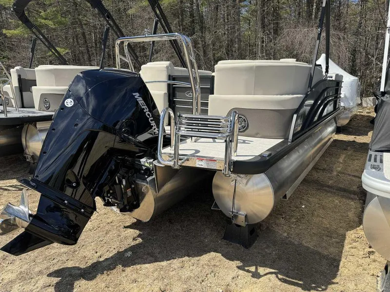 Slide: The Image of 2024 Harris Sunliner 210 pontoon boat with Mercury outboard engine, parked on sandy ground. - 9