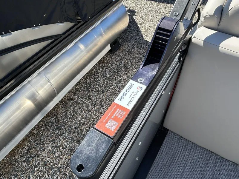 Slide: The Image of 2024 Harris Sunliner 210 boat detail, featuring seating and metal components on gravel surface. - 14