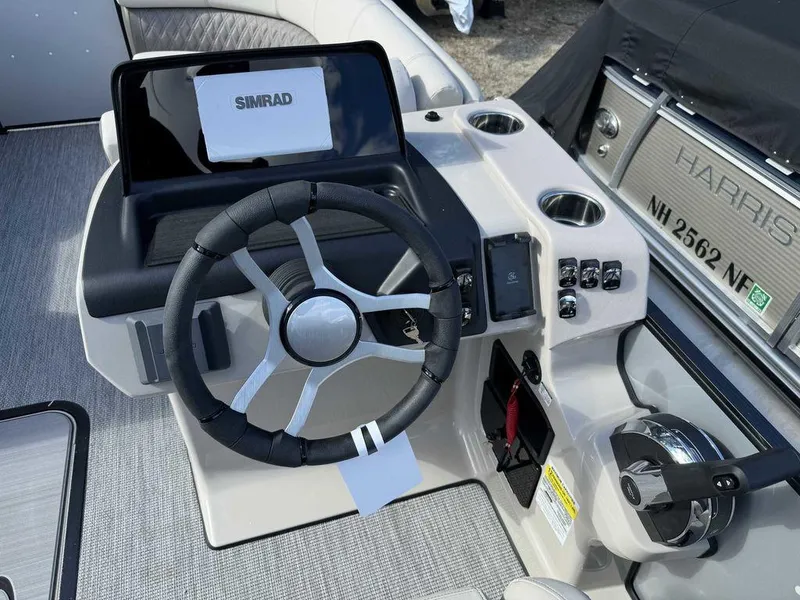 Slide: The Image of 2024 Harris Sunliner 210 boat dashboard with steering wheel and Simrad display. - 6