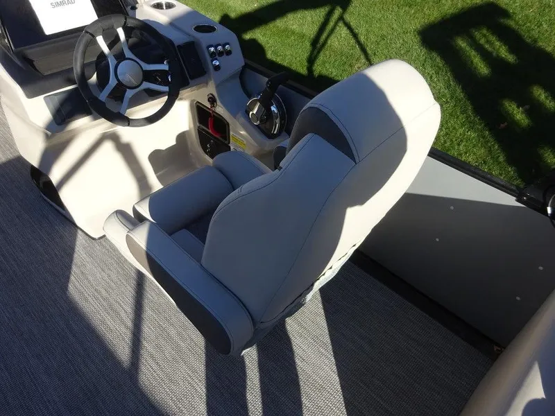 Slide: The Image of 2024 Harris Sunliner 210 boat interior with steering wheel and captain's chair. - 11