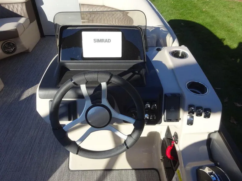 Slide: The Image of 2024 Harris Sunliner 210 boat dashboard with steering wheel and Simrad display. - 15
