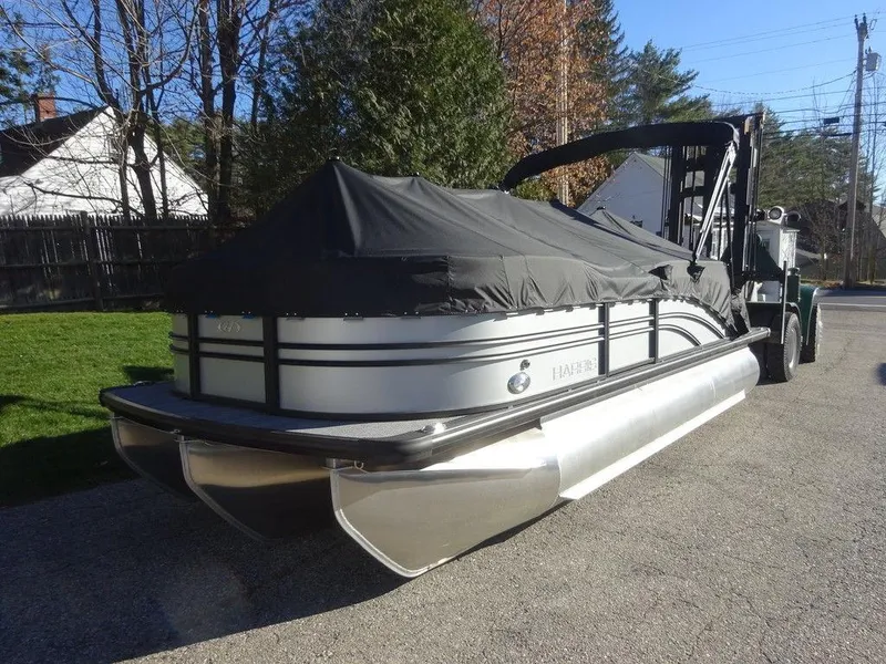 Slide: The Image of 2024 Harris Sunliner 210 pontoon boat with cover on a trailer. - 3