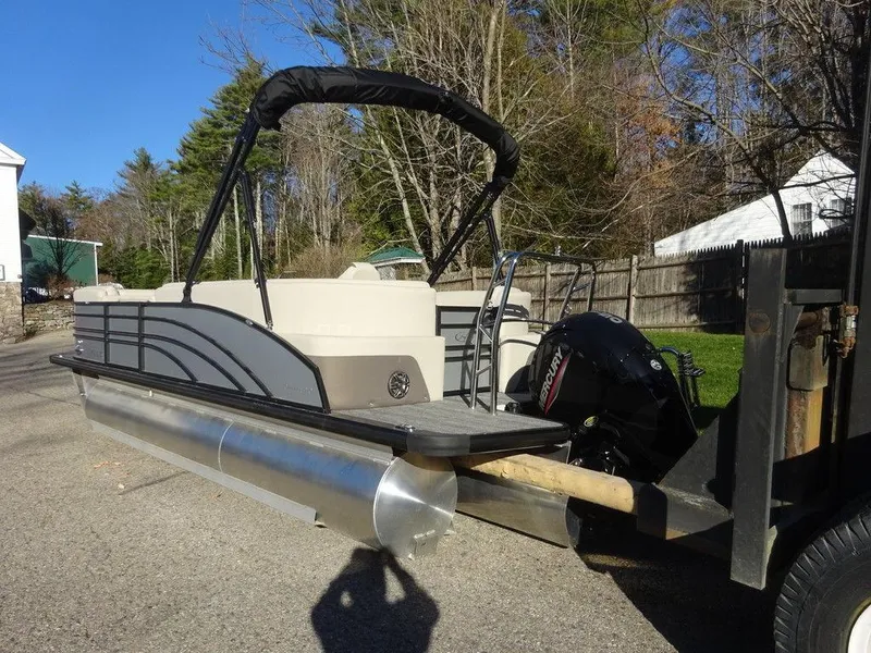 Slide: The Image of 2024 Harris Sunliner 210 pontoon boat on trailer, parked outdoors. - 6