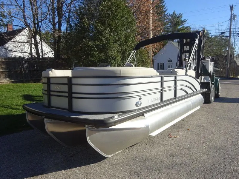 Slide: The Image of 2024 Harris Sunliner 210 pontoon boat parked on a sunny street. - 7