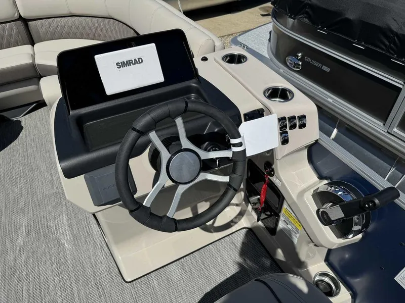 Slide: The Image of 2024 Harris Sunliner 210 boat dashboard with steering wheel and Simrad display. - 4
