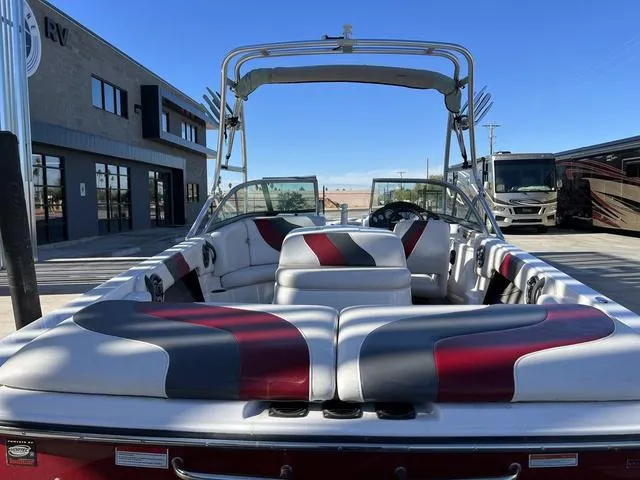 Slide: The Image of 2006 Moomba Outback boat with red and gray interior, parked outdoors. - 14