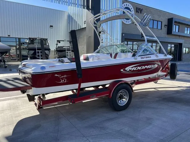Slide: The Image of 2006 Moomba Outback red and white ski boat on trailer outside dealership. - 3