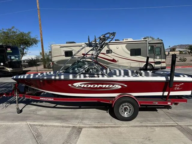 Slide: The Image of 2006 Moomba Outback boat on a trailer, parked near RVs. - 4