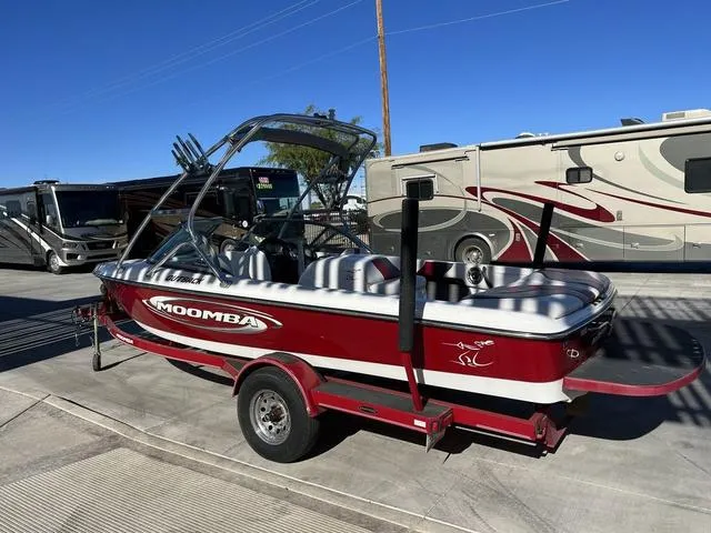 Slide: The Image of 2006 Moomba Outback boat on trailer, parked near RVs. - 6