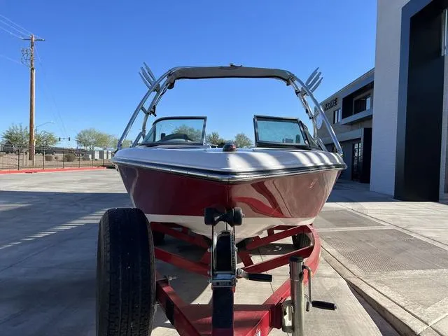 Slide: The Image of 2006 Moomba Outback boat on a trailer, front view, parked outdoors. - 7
