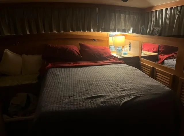 Slide: The Image of Cozy bedroom in a 1985 Silverton 40 Double Cabin yacht with dim lighting. - 7