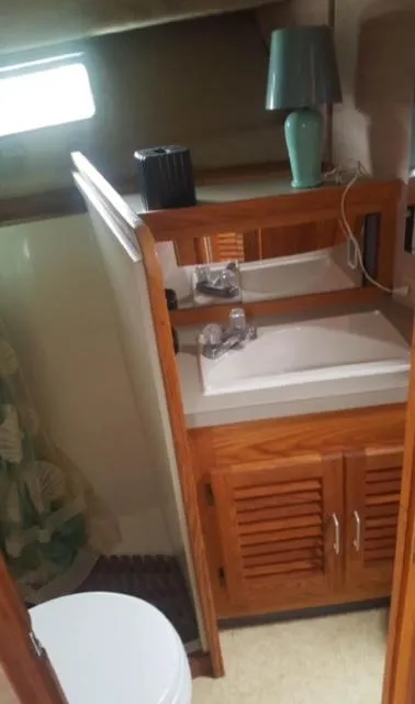 Slide: The Image of 1985 Silverton 40 Double Cabin bathroom with sink, cabinet, and lamp. - 9