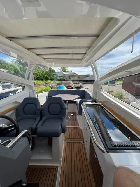 Slide: The Image of Interior of a 2019 Nimbus W9 boat with seating, steering, and kitchenette. - 11