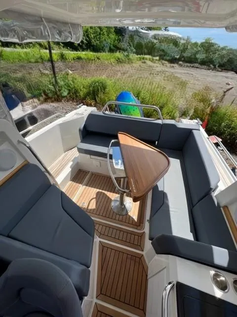 Slide: The Image of 2019 Nimbus W9 boat with cushioned seating and wooden table. - 13