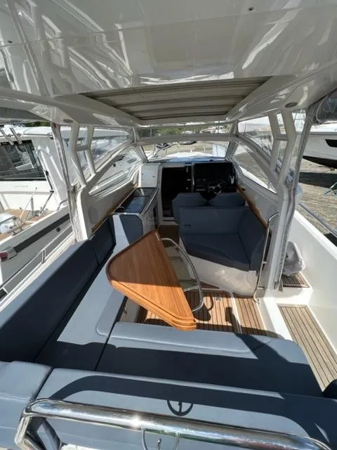 Slide: The Image of 2019 Nimbus W9 boat interior with seating and wooden table. - 14
