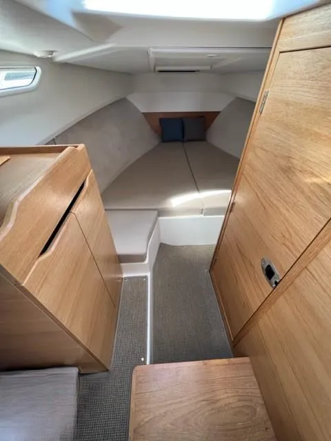 Slide: The Image of 2019 Nimbus W9 boat interior cabin with wooden furnishings and cozy sleeping area. - 16