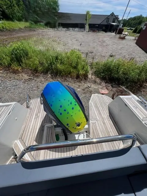 Slide: The Image of Colorful outboard motor on a 2019 Nimbus W9 boat docked near a grassy area. - 20