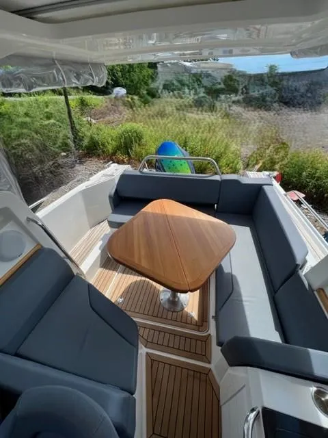 Slide: The Image of 2019 Nimbus W9 boat with outdoor seating and wooden table. - 8