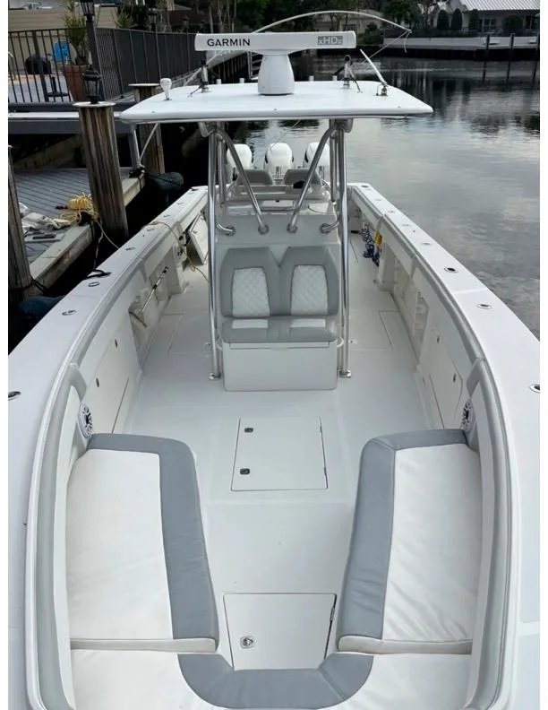 Slide: The Image of 2009 Jupiter 38 FS boat with white and gray seating, docked by the water. - 13