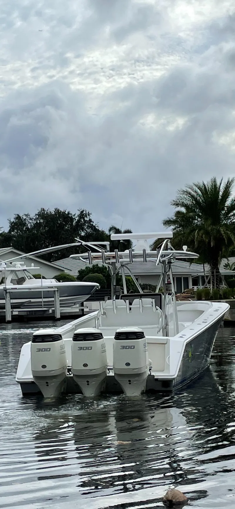 Slide: The Image of 2009 Jupiter 38 FS boat with triple outboard engines docked in a marina. - 2