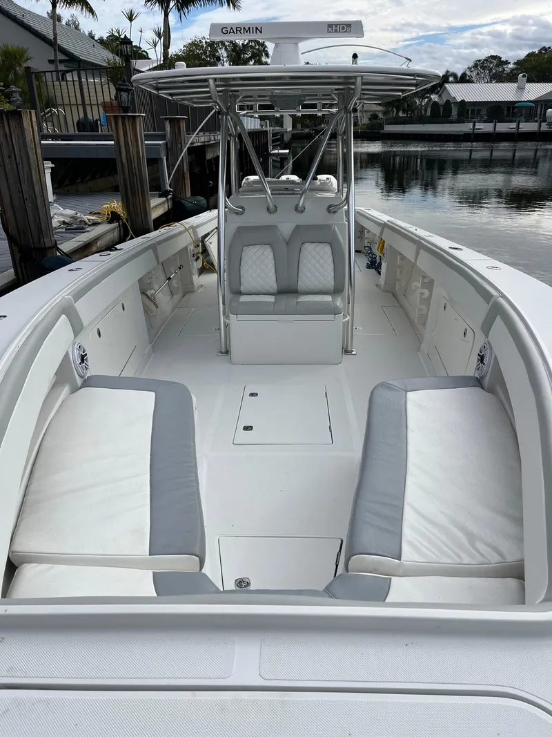 Slide: The Image of 2009 Jupiter 38 FS boat with white seating and center console, docked by the water. - 23