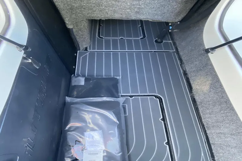 Slide: The Image of 2023 Nautique Super Air Nautique G25 Paragon storage compartment with grey flooring. - 15