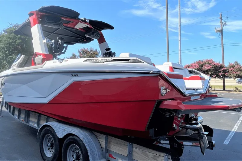 Slide: The Image of 2023 Nautique Super Air Nautique G25 Paragon boat on trailer, red and white exterior. - 4