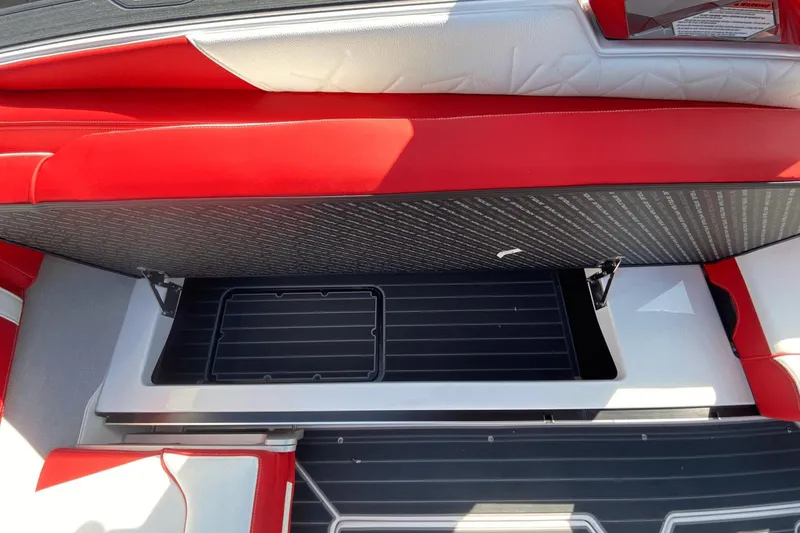 Slide: The Image of 2023 Nautique Super Air Nautique G25 Paragon storage compartment with red and white upholstery. - 23