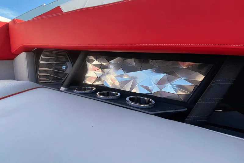 Slide: The Image of 2023 Nautique Super Air Nautique G25 Paragon interior with red upholstery and cup holders. - 37