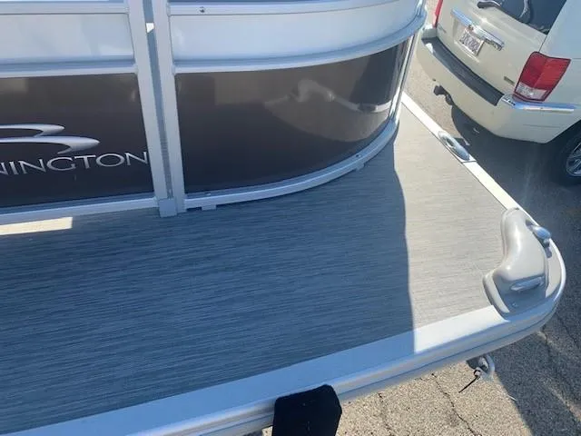 Slide: The Image of 2023 Bennington SX Line boat rear deck in a parking lot. - 12